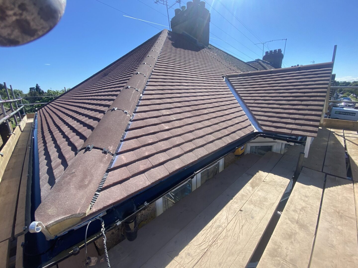 Overhead shot of roofing in Surrey, featuring a mix of shingled, tiled, and metal roofs on homes in a residential area.